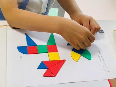 ピグマリオンの学具「色板トントン」を使ってプリントの上に図形を置いている